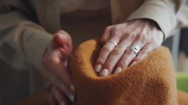 Özel ekipman üzerine keçeli şapkayı yassılaştıran kadın ellerinin seçici odak noktası.