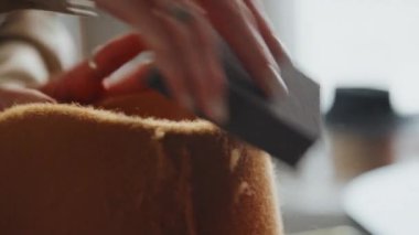 Yeni keçeli şapka üzerinde son rötuşları yapan tanınmayan beyaz kadın şapkacının görüntüsü.