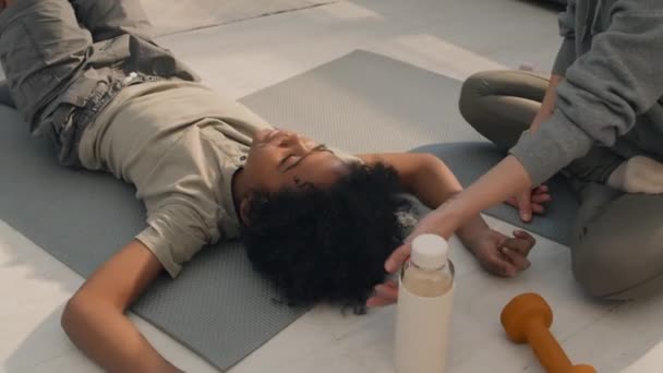 拍下小男孩躺在地板上的照片 在他妈妈照顾他的时候 他做完体育锻炼后放松了下来 — 图库视频影像