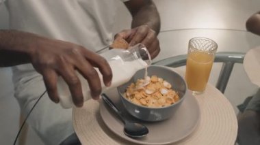 Siyah adamın gözlüklü bir fotoğrafını çek. Masanın arkasında ailesiyle yemek yiyor.