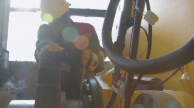 Aydınlık bir günde makine fabrikasında çalışan işçilerin seçici odak yavaşlığı cıvata ya da ingiliz anahtarı ile büyük vites çekici çerçeve içinde fındık