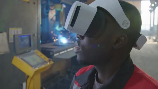 Siyah Erkek Mühendisin Sanal Gerçeklik Gözlüğü Taktığı Fabrikada Arkaplanda Kaynak — Stok video