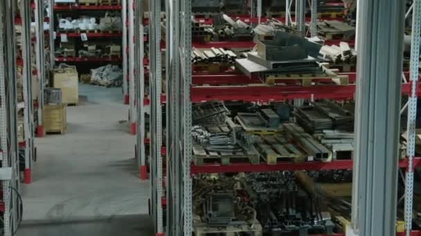 機械工場の倉庫で予備品が付いているラックの複数の列のキルトの高い角度人ショット無し — ストック動画