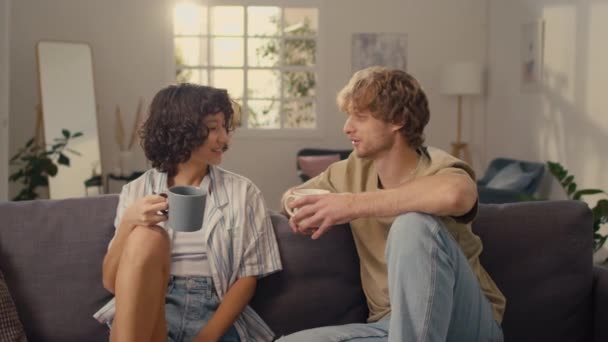 Medium Shot Young Married Couple Sitting Sofa Drinking Hot Drinks — Stock Video