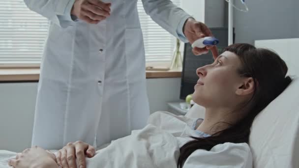 Średnie Ujęcie Bliska Kobiety Lekarza Mierzącego Temperaturę Jej Pacjenta Rasy — Wideo stockowe