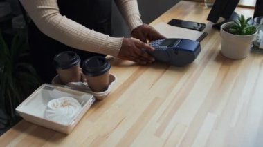 Tanımlanamayan bir müşterinin siparişi alıp dijital saat üzerinden terminalde ödediği görüntüler.