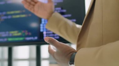 Tanımlanamayan siyah adam ekranın önünde duruyor ve programlama kodlarıyla seyircilere konuşma yapıyor.