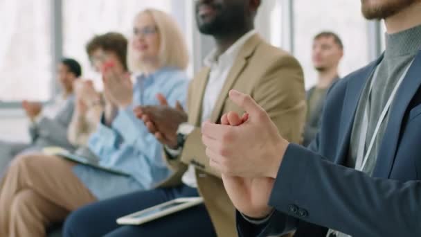 有选择地专注于坐在拥挤的会议室里的难以辨认的白人男子 向演讲者欢呼 — 图库视频影像