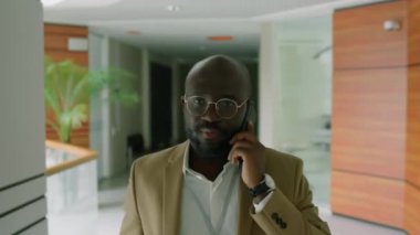 Formalite icabı iş adamının modern binanın koridorunda telefonla konuşurken görüntüsü.