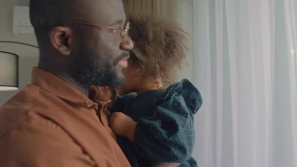Чорний Чоловік Тримає Свою Дочку Вигулюючи Туди Сюди Коли Вона — стокове відео