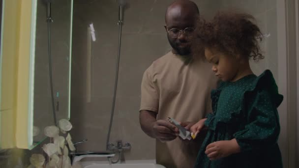 Black Single Father Helping His Daughter Standing Bathroom Coaster Brushing — Stock Video