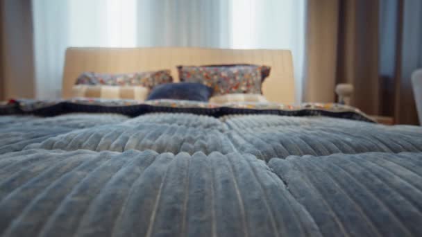 大きい窓の隣の青い色の自然な繊維の毛布で覆われる二重ベッドの選択的な焦点 — ストック動画