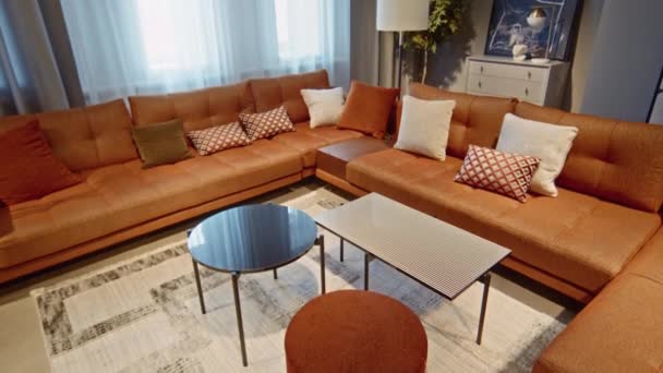 Modernes Wohnzimmerinterieur Mit Langem Orangefarbenem Ecksofa Und Zwei Couchtischen Davor — Stockvideo