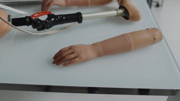 医療施設の白いタブレットに横たわる現代の義足 テーラーメイドの腕と片足 — ストック動画