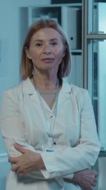 Beyaz önlüklü kadın yüksek teknoloji mühendisinin dikey portresi laboratuarında duruyor ve arkasında 3D model var.