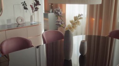 Basit bir vazoya odaklanın. Cam masa üzerinde plastik bitkiler ve mobilya mağazasında düşük asılı lamba olsun.