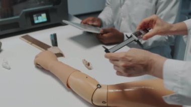 Tanımlanamayan kadın ve erkek mühendisler modelleri ölçmek için dijital kalibre gibi araçlar kullanarak yeni protez yaratmak için çalışıyorlar.