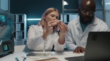 Sarışın kıdemli müteahhit, kıdemsiz meslektaşlarının 3 boyutlu baskı makinesinin protez üretme sürecini anlatıyor.