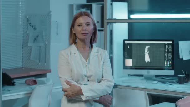 身穿白衣的女高科技工程师站在实验室里的画像 她身后陈列着3D模型 — 图库视频影像