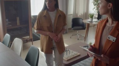 Mobilya perakendecisinde gezinen potansiyel alıcının görüntüsü, satış müdürüne gerekli parçaları ararken sorular sorması.