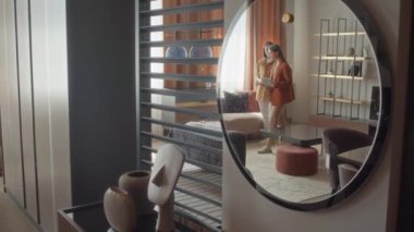 Mobilya mağazası müdürünün müşterisine geniş oturma odasını tarif eden ve gösteren ayna yansıması.