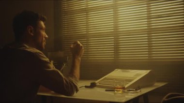 Sepia, beyaz bir adamın gömleğini giyip sigara içerken ve bakışlarını kaçırırken, sonra cüzdan okurken, teneke ışıklı odada daktiloyla masada otururken.