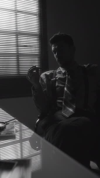 办公室里悲观中年男人的垂直单色平底锅照片 穿着吸烟 然后在房间靠窗的烟灰缸里压碎香烟 — 图库视频影像