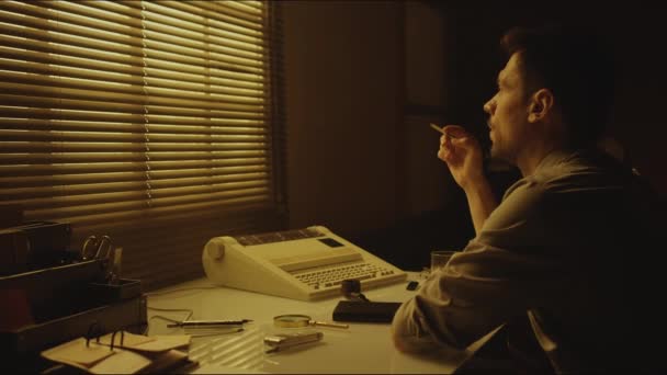 塞皮亚侧拍的是一位身穿衬衫 留着胡子的白人男子 在公寓抽烟时 一边想一边用百叶窗看着窗户 — 图库视频影像
