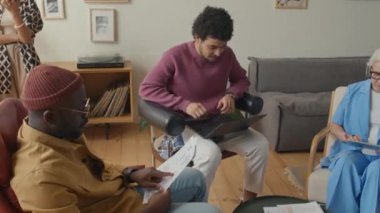 Genç adam dizüstü bilgisayarda çalışıyor, sonra başarılı projeyi kutluyor ve gün içinde iş arkadaşlarına beşlik çakıyor.