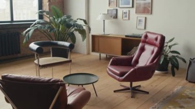 Küçük kahve masasının etrafında rahat koltukları olan modern çalışma odasının içinde.