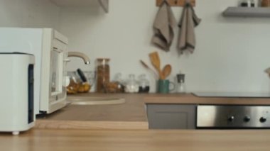 Orta bölüm bıçaklama sahnesinde tanınmayan bir adam mikrodalgaya yemek koyar ve modern aydınlık mutfağa gider.