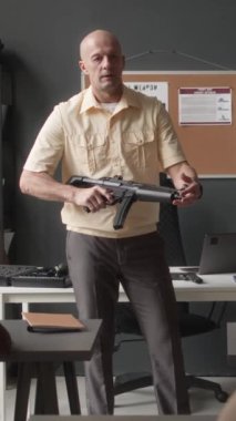 Askeri akademi sınıfında tüfek kullanımı üzerine dikey bir sınıf. Askeri eğitmen tüfekle ayakta duruyor.