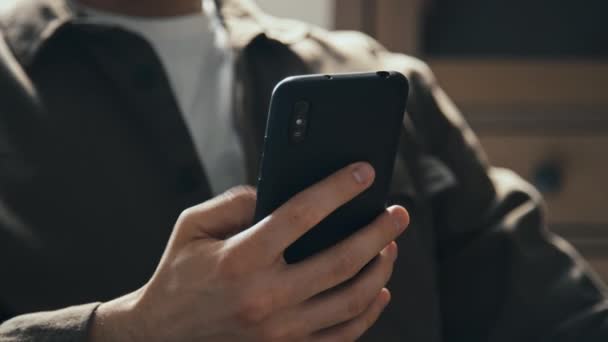 Tanımlanamayan Bir Adamın Telefon Kaydırağını Kullanarak Mesajları Okuyarak Kapalı Otururken — Stok video