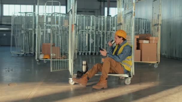 全面拍摄婴儿男性仓库工作人员喝茶或喝咖啡 在工作场所休息时坐在货柜车上微笑的照片 — 图库视频影像
