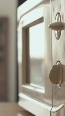 Mikrodalga fırın zaman kontrolünü kullanarak ve mutfakta yemek ısıtırken dikey saplama kenarı görüntüsü.