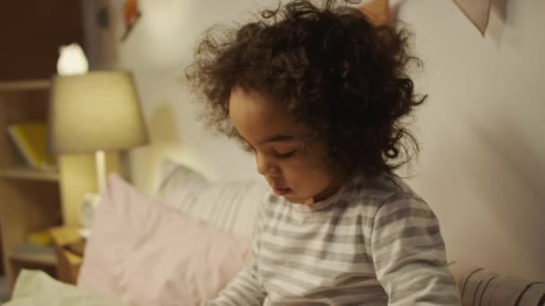 Tiro Inclinación Lateral Niño Afroamericano Cinco Años Pijama Sentado Cama — Vídeo de stock