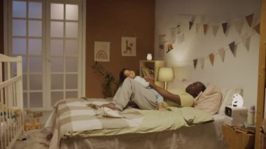Afrika kökenli Amerikalı bir babanın yatakta yattığı ve iki yaşındaki iki yaşındaki melez bir kızın akşamları süslü yatak odasında kucağında uyuduğu bir fotoğraf.