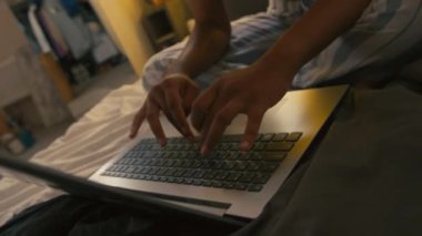 Yakından bakınca, evde yatarken dizüstü bilgisayarında yazan Afrikalı Amerikalı bir serbest yazar yavaşlıyor.