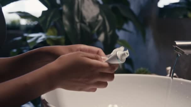 非洲裔美国女青年用牙膏挤压牙刷和刷牙的侧斜特写 当代磨牙阁楼浴室的镜子 — 图库视频影像