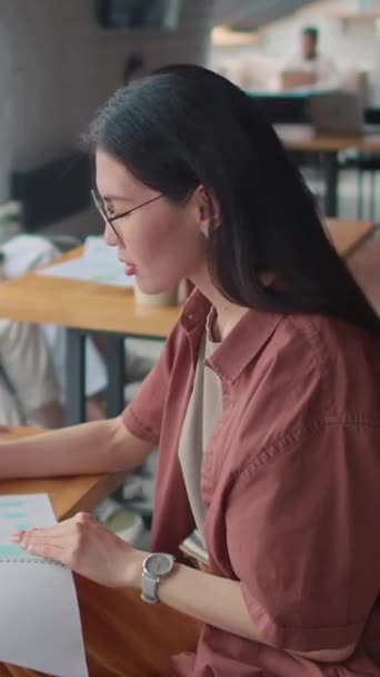 Retrato Vertical Mediano Una Joven Estudiante Asiática Gafas Sentada Mesa — Vídeo de stock