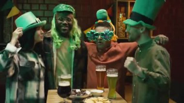 Barda yeşil şapkalarla zıplayan ve zümrüt birayla Aziz Patrick Günü partisi yapan enerjik çok ırklı arkadaşların orta boy portresi.