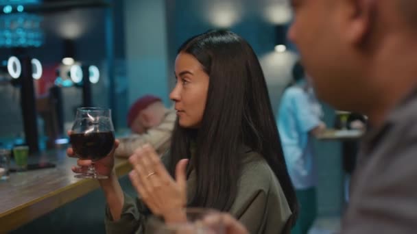 美しいBiracialの女性がワインを飲んで バーでビールと話してからメガネを飲む映像をサイドチェスト — ストック動画