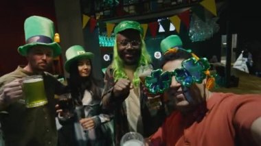 POV UGC, kulüpte İrlanda Aziz Patrick Günü 'nü kutlarken kameraya bakan ve bardakları tokuşturan çok ırklı arkadaşlarının el kamerasıyla çekilmiş görüntüleri.