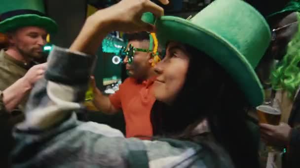サンパトリックデーを祝うアルコールとクラブの友人とのパーティーで緑の帽子で魅力的なBiracial女性のPov映像 — ストック動画