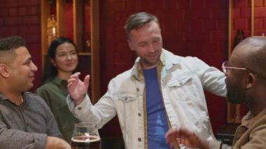 Çeşitli erkek ve kadın arkadaşlarının akşamları barda toplanıp birbirlerini selamladıkları ve mutlu bir şekilde konuştukları görüntüler.