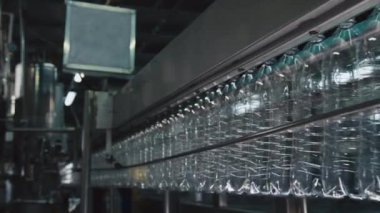 Hiçbir insan içecek fabrikasında otomasyon robotik taşıyıcı boyunca hareket eden boş plastik şişelerin yan görüntülerini çekmez.