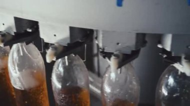 Hiçbir yüksek açılı insan içki fabrikasındaki plastik şişelere gazlı içecek döken endüstriyel makineyi doldurmaya yaklaşamaz.