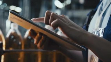 İçki fabrikasındaki yeni soda üretimini değerlendirirken kaliteli protokol dolduran beyaz kadın mühendisin yan çekimleri.