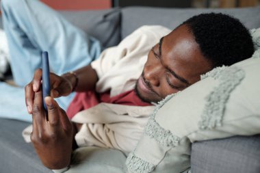 Rahat bir adam kanepede uzanıp fotoğraflara ya da cep telefonundaki paylaşımlara bakıyor ya da internetten ilginç videolar izliyor.