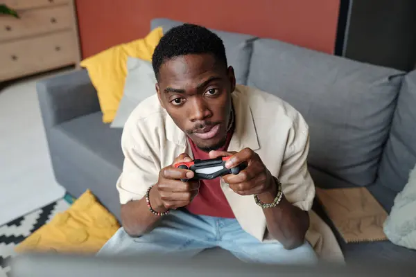 紧张的非洲裔美国人 手握游戏垫 在电子游戏中看着电脑屏幕 看着角色 — 图库照片